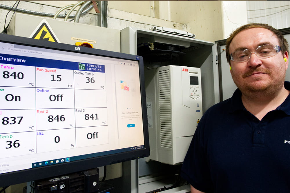 A man is standing in front of a monitor.