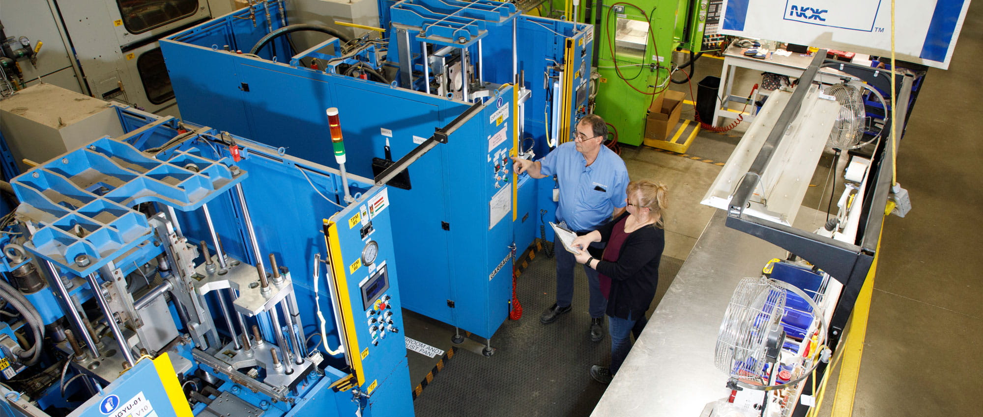 Two work colleagues are standing by one of the new Tung-Yu presses.