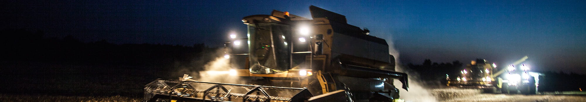 A plow machine plows through field at night