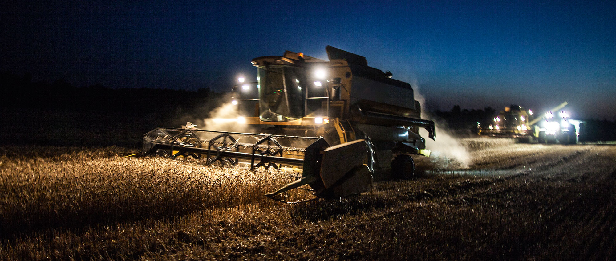 A plow machine plows through field at night