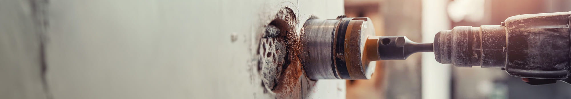 Close up of a drill head drilling a hole in the wall
