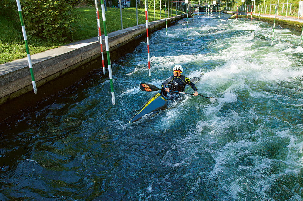A person kayaking through a White-water canal.