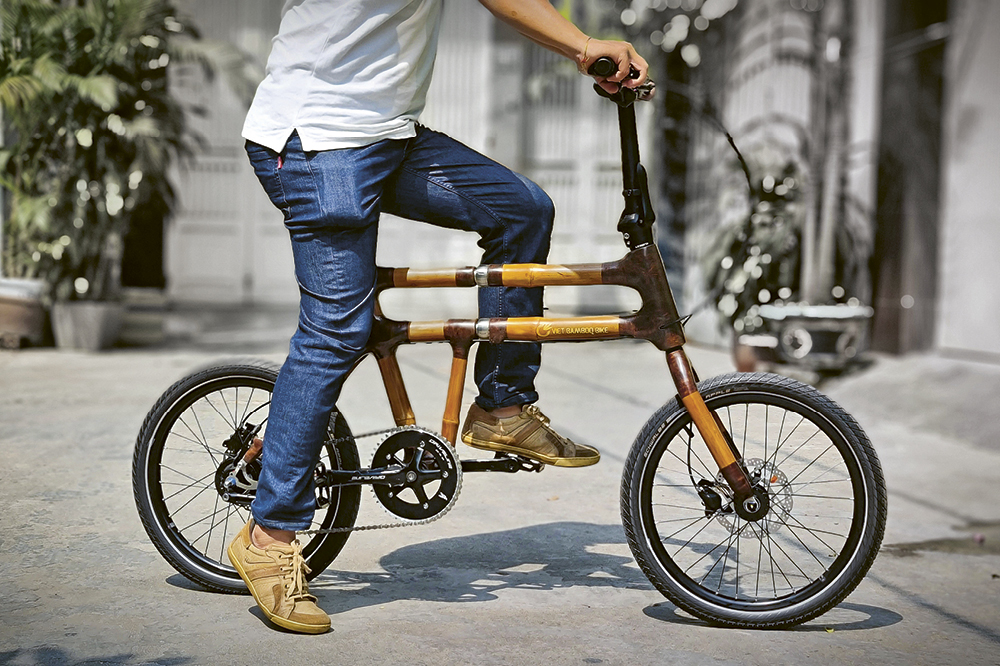 A person sits on a Vet Bamboo Bike made of bamboo.