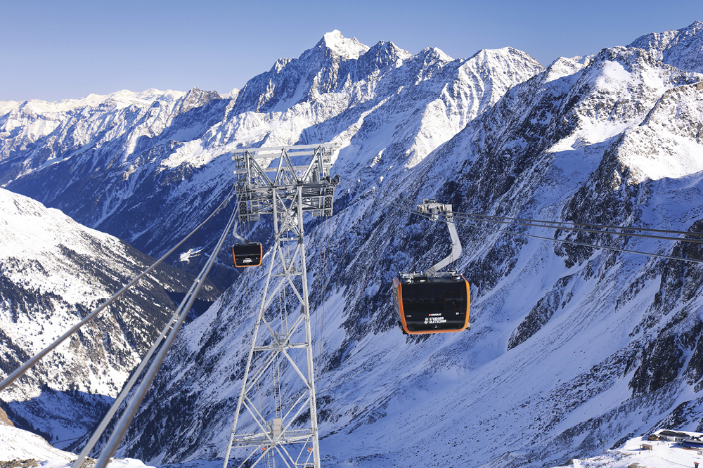Cable car in the middle of a snow-covered mountain range.