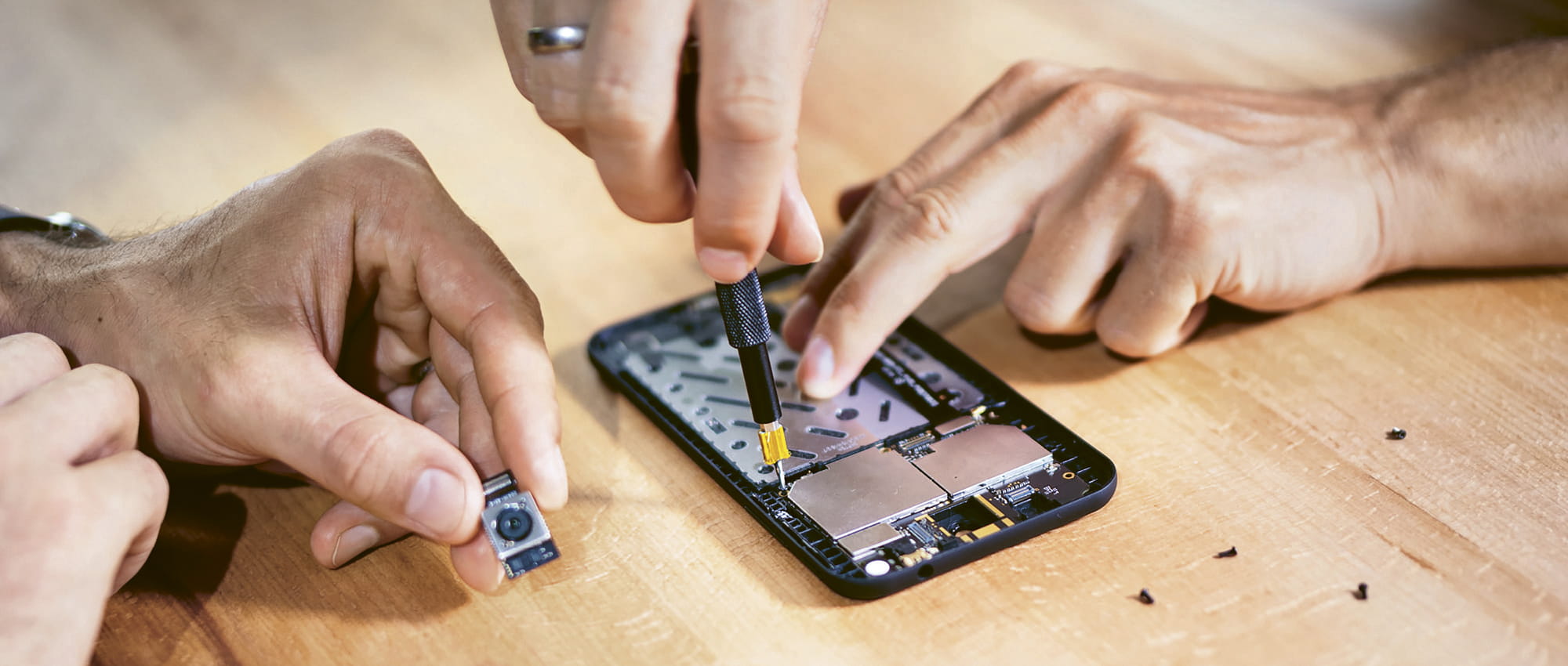 Hands take apart a cell phone from Shift.