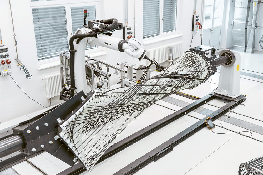 A robotic arm weaves architectural components