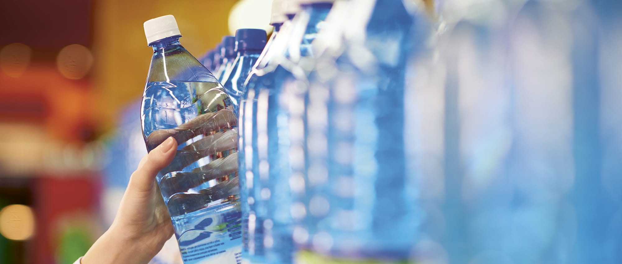 A water bottle is grabbed from a shelf. Copyright: iStock / mediaphotos
