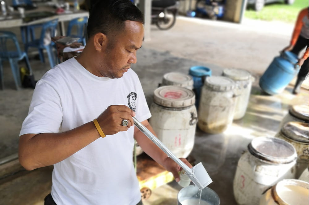 A man fills rubber into a bottle