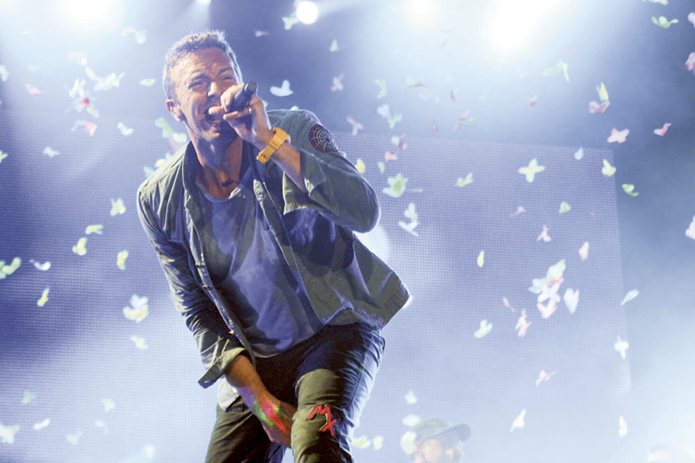 Lead singer Chris Martin of Coldplay sings on stage.