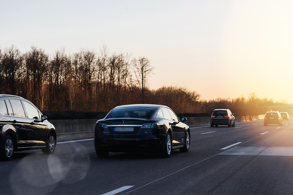 Cars driving on a highway during sunset.