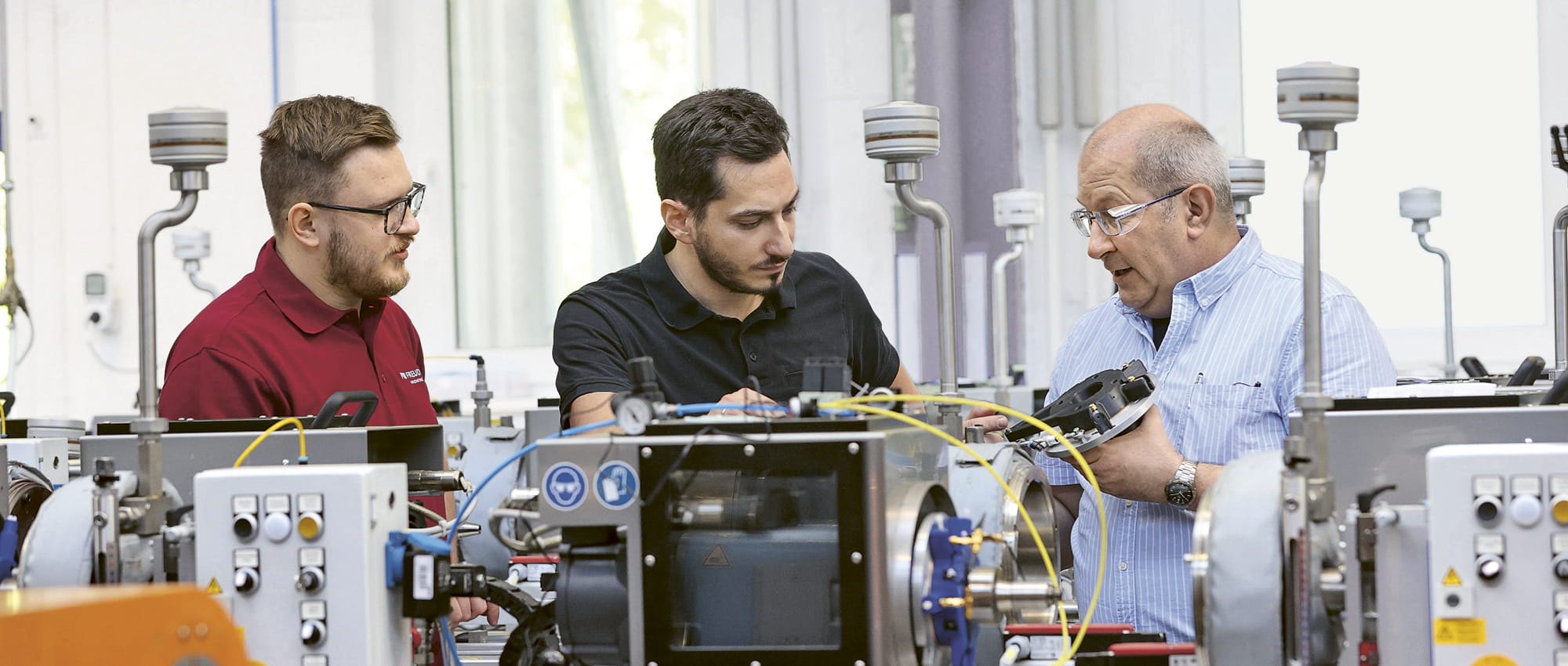 Robert Leins, Manager of the Weinheim test facility in Germany, inspects a new test stand along with two colleagues.