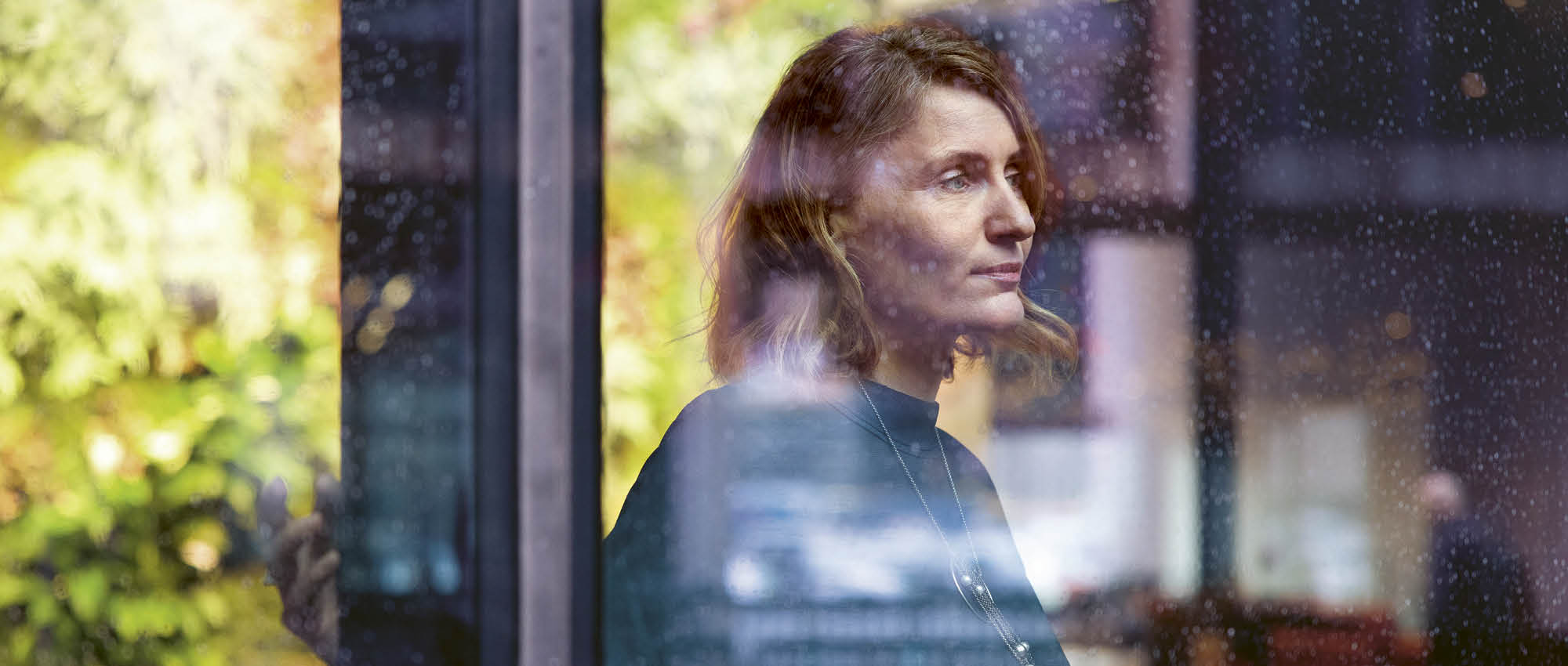 Portrait of a women looking out of a window.