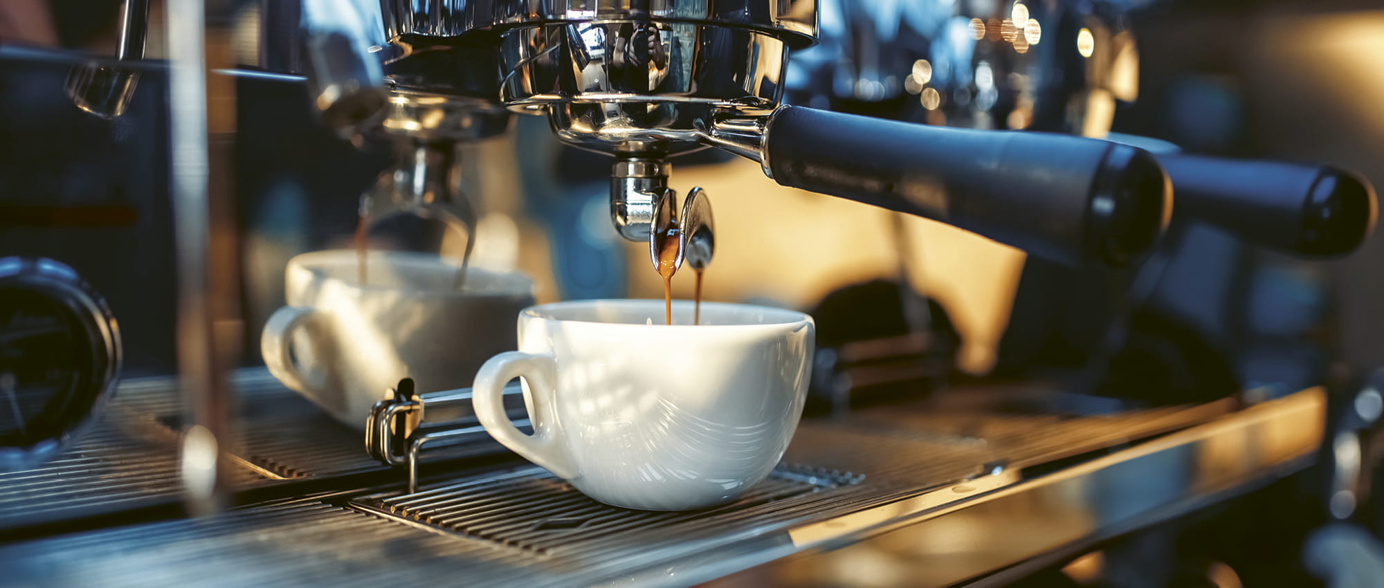 Coffee from a coffee machine drips into a cup. Copyright: Adobestock/Nomad_Soul