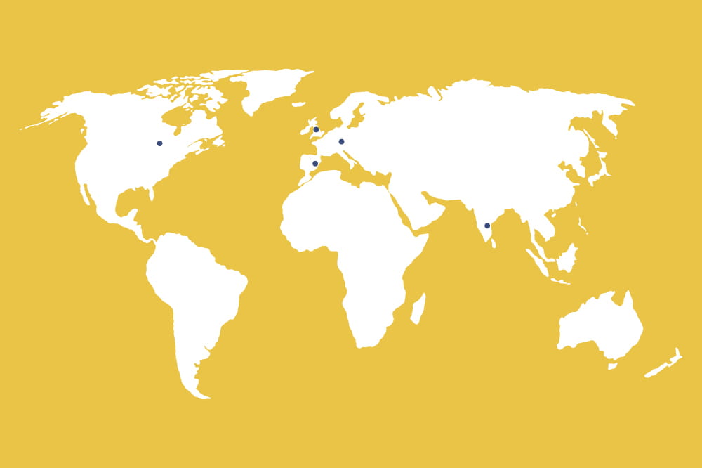 Illustration of a world map against a yellow background and blue dots in the USA, Europe and India.