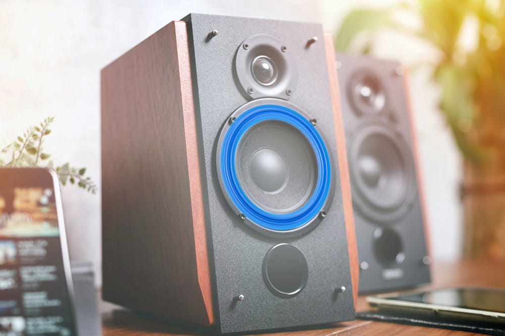 Loudspeaker boxes stand on a table.