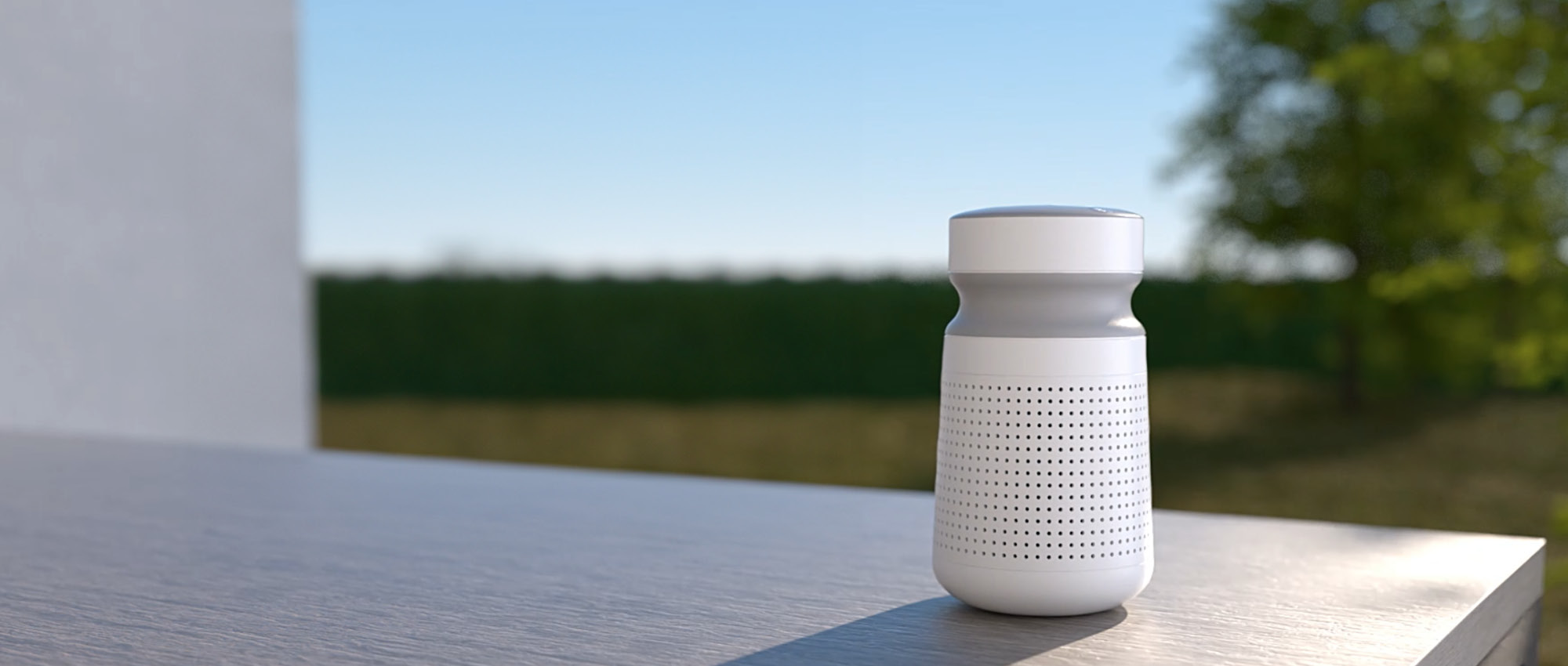 A loudspeaker stands on a table outside in the landscape.