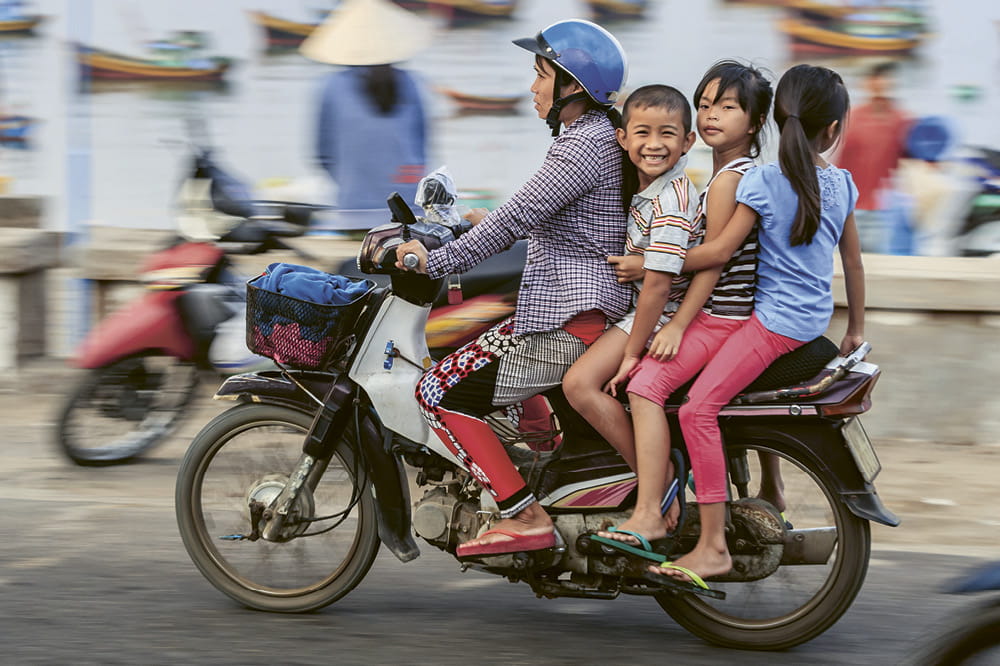 Woman with children on motorcycle.