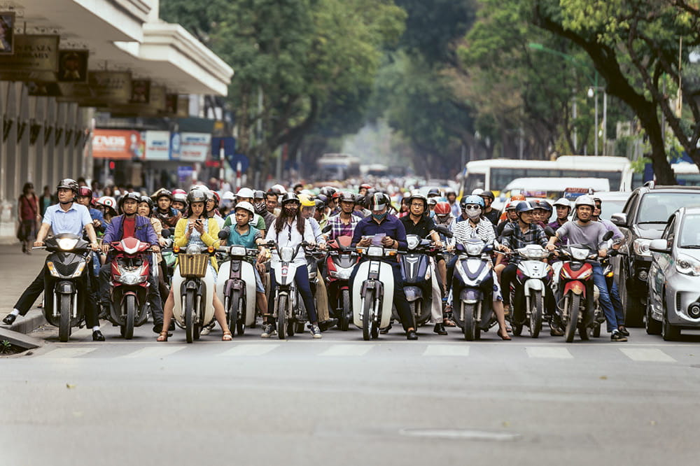 Many people on motorcycles waiting in front of a crosswalk. Copyright: iStock/Artit_Wongpradu