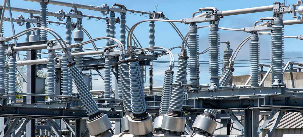 High-voltage electrical substation with insulators and power lines.