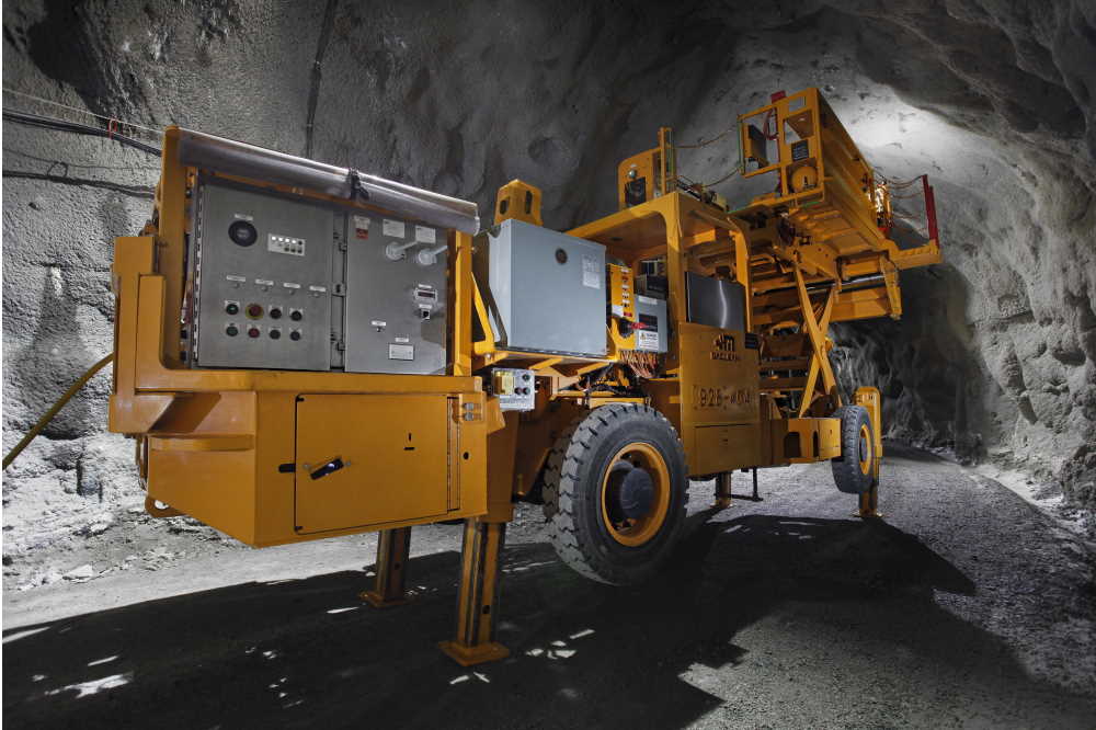 a huge orange MacLean mining machine operating in an underground mine