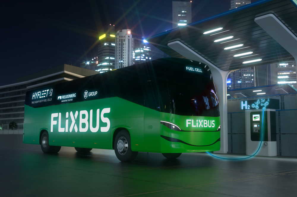 Computer-generated image of a fuel cell bus with the logos of Flixbus, ZF and Freudenberg at a hydrogen refueling station at night