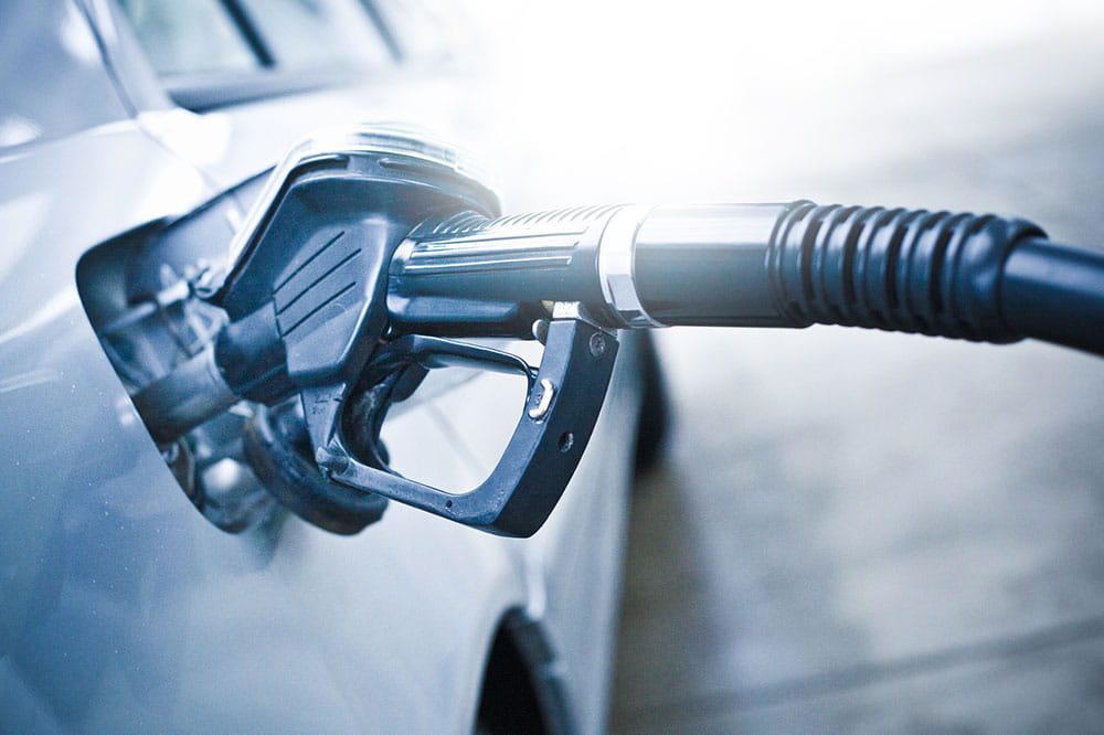 Close up of white car refueling at gas station