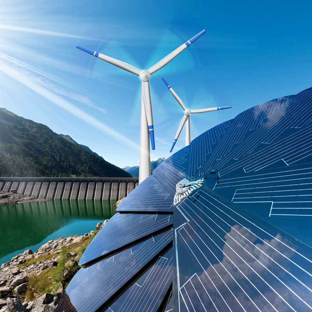 Detail of a solar collector in the shape of a flower in front of two wind turbines and a dam in mountains with blue sky and sun rays