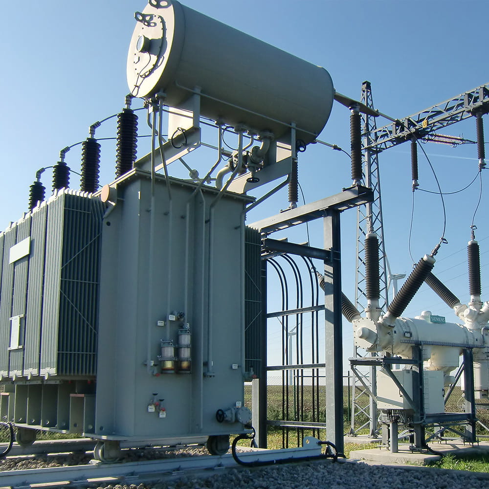 Power station for energy transmission and distribution on meadow under blue sky