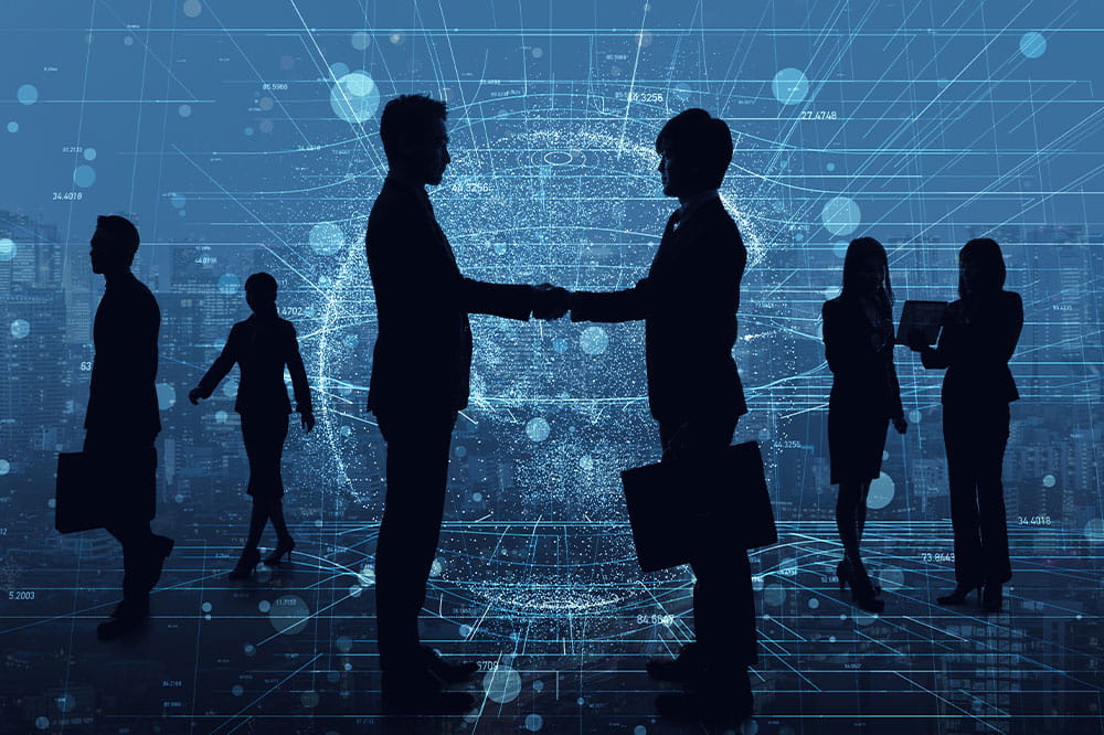 Silhouette of several business people while two of them shake hands and global network is depicted in the background