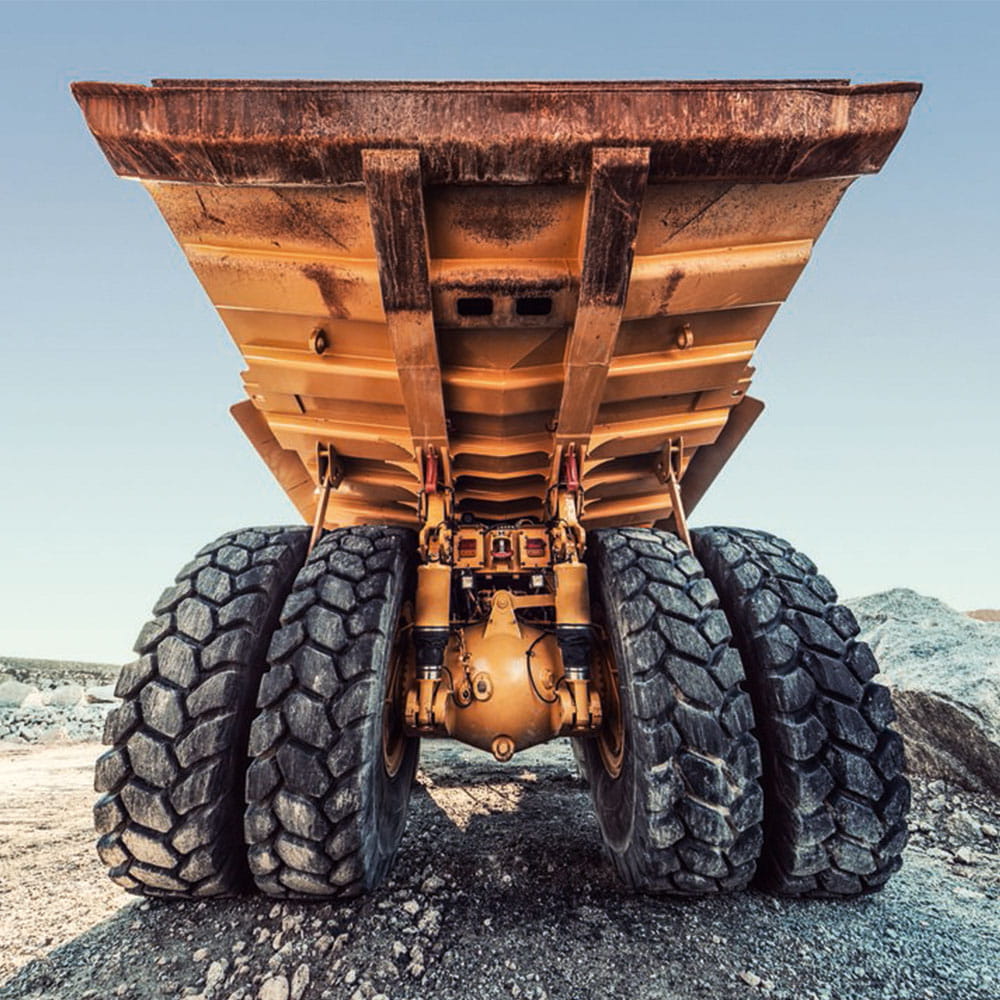 A very wide angle view of a massive off-highway dump truck on a large construction site