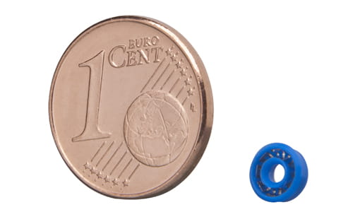 Small Forseal from Freudenberg Sealing Technologies compared in size to a cent piece in front of a white background