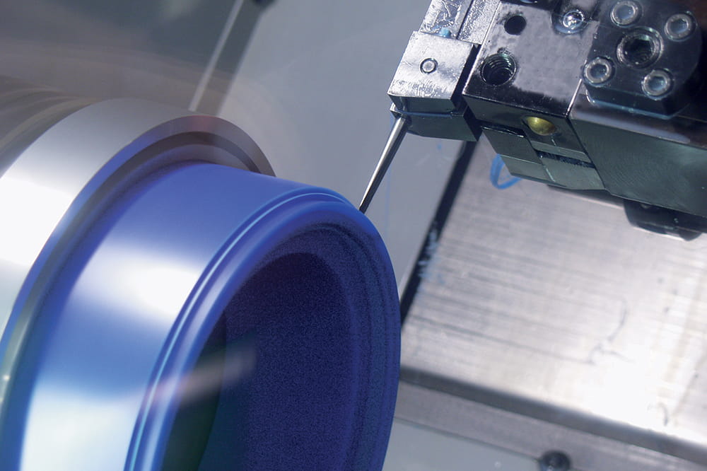 Lateral view of a CNC machine that produces a blue sealing profile made of Polyurethane