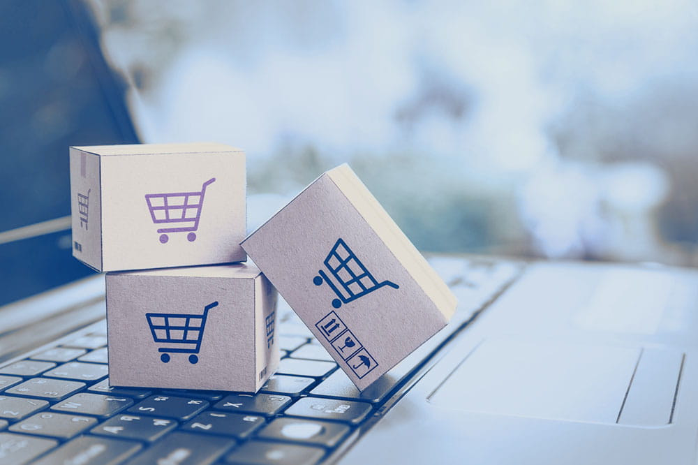 Notebook with packages on the keyboard with blue and red carts on them 