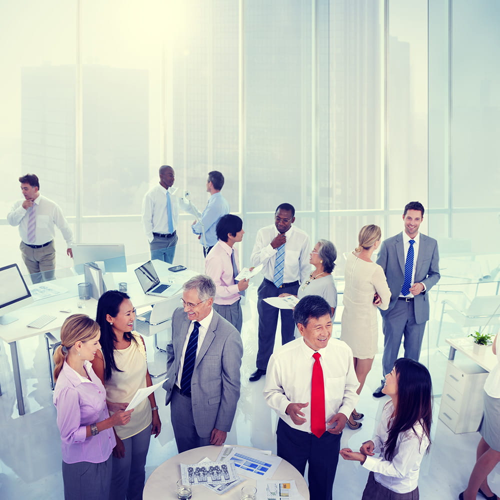 Women and men in business attire standing together in an office