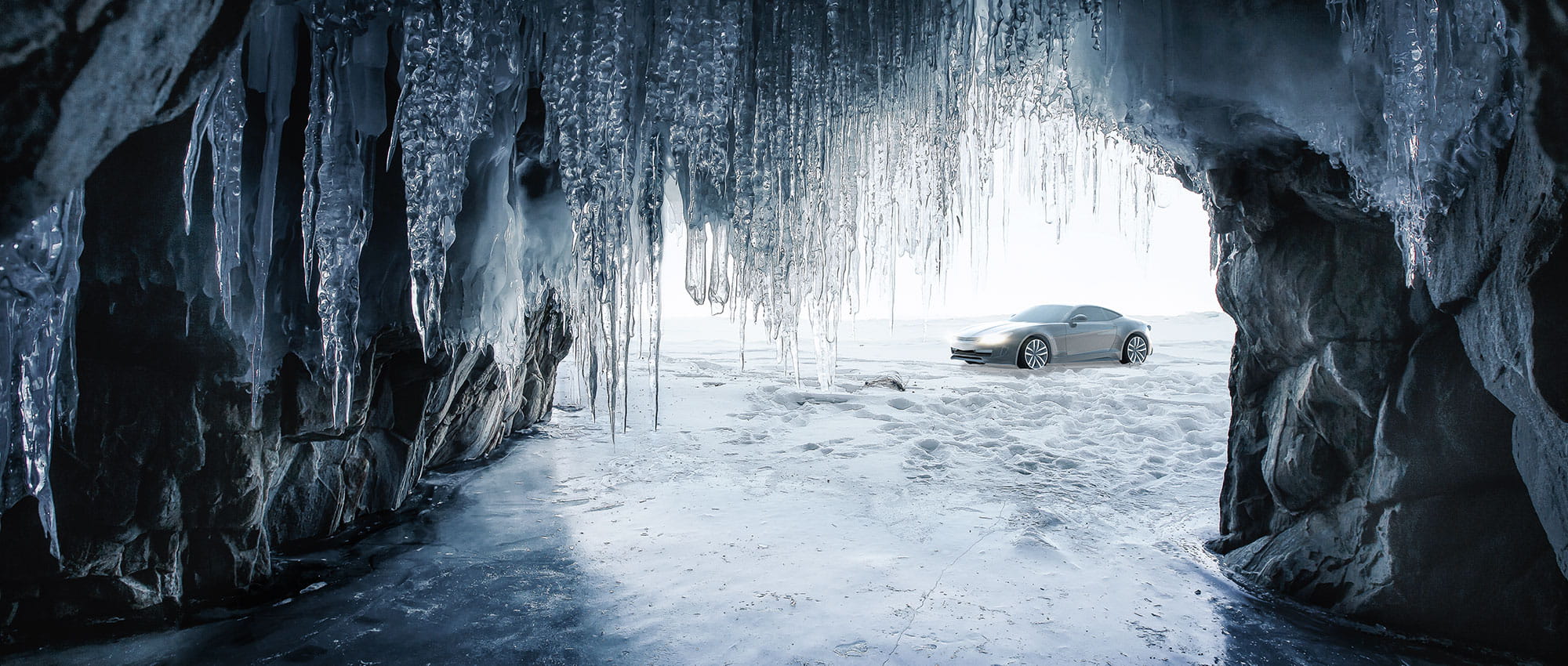 Sicht aus einer Eishöhle und vor der Eishöhle steht ein Auto