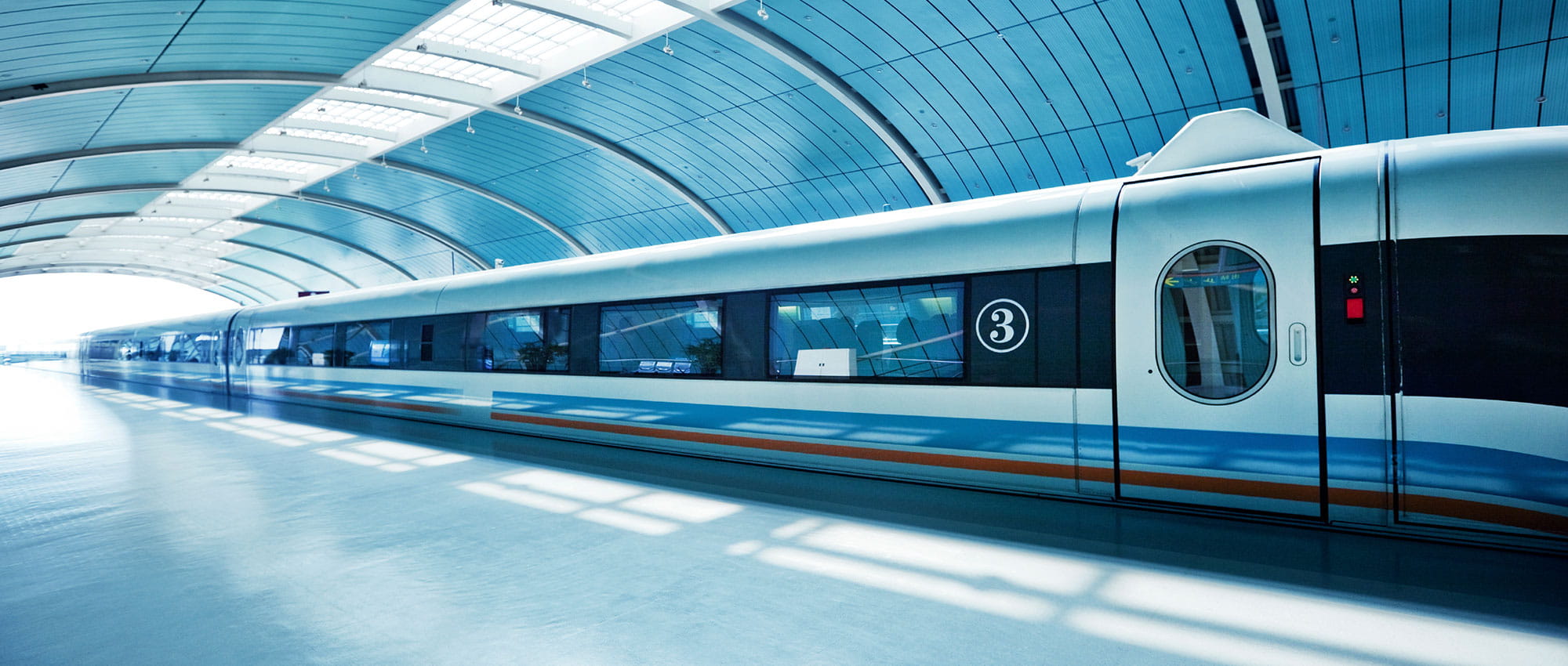 Zug im überdachten Bahnhof hält an einem Gleis