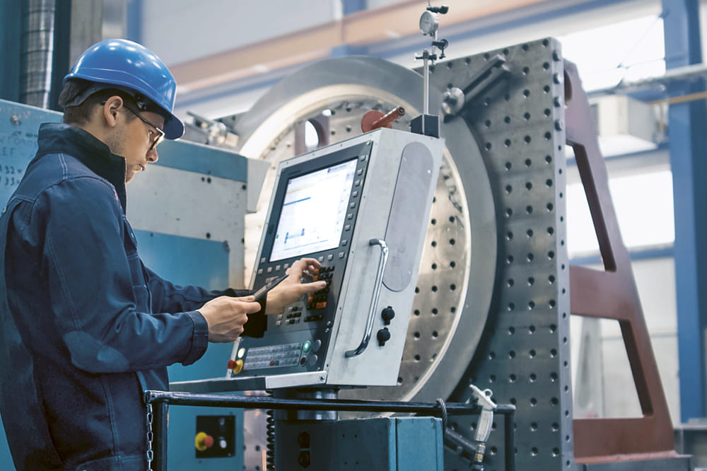 Mitarbeiter bedient eine industrielle Maschine.