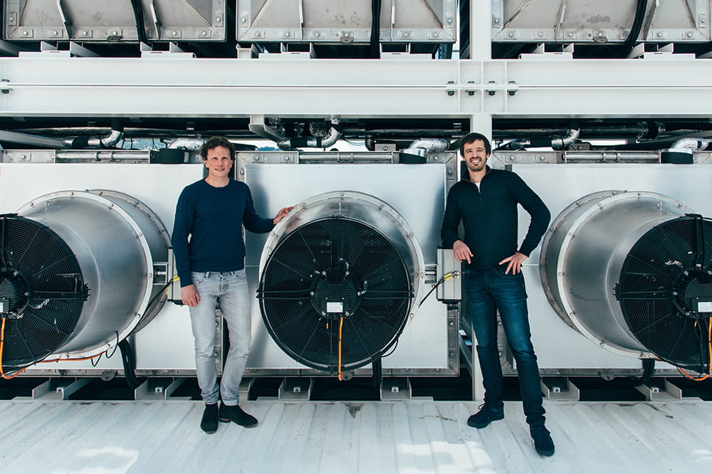 Zwei Männder, die neben großen Ventilatoren stehen