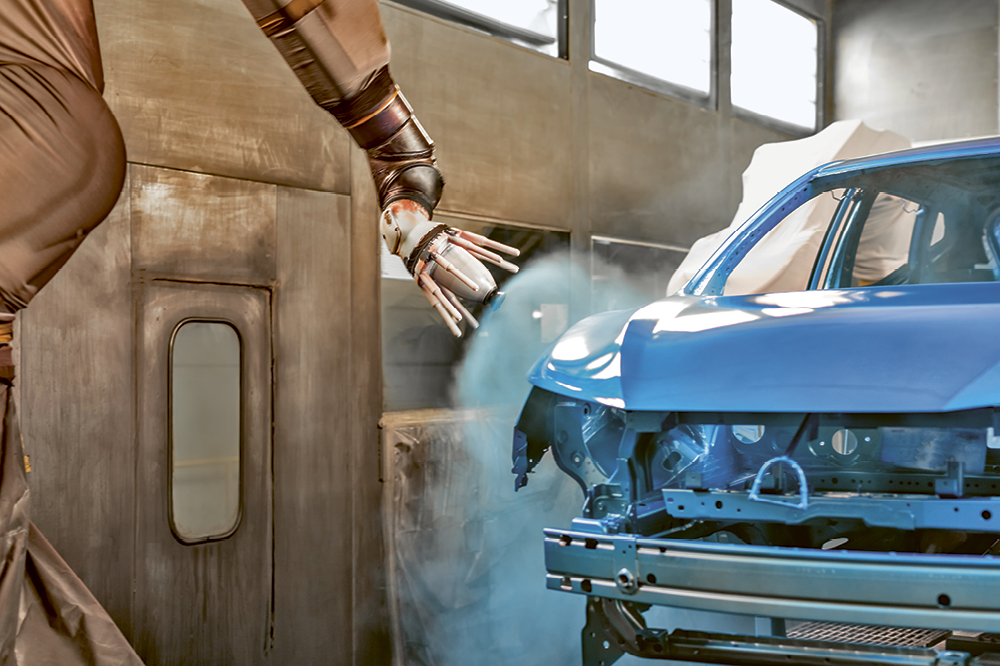Roboter-Lackierarm sprüht blaue Farbe auf eine Autokarosserie in einer Fabrik. Copyright by Shutterstock /  Vadim Kulikov