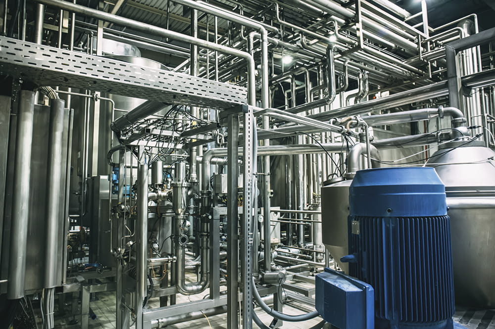 Eine Produktionsanlagen in der Prozessindustrie mit zahlreichen Pumpen, Tanks, Ventile, Rohre und Leitungen.