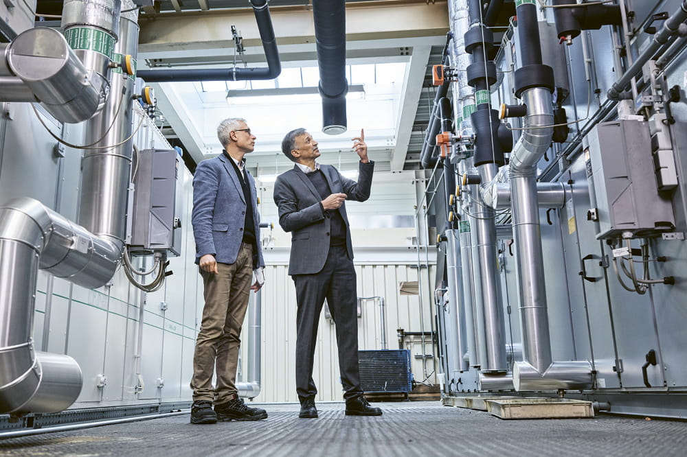Zwei Männer schauen sich Kompressoren in einer Fabrik an.
