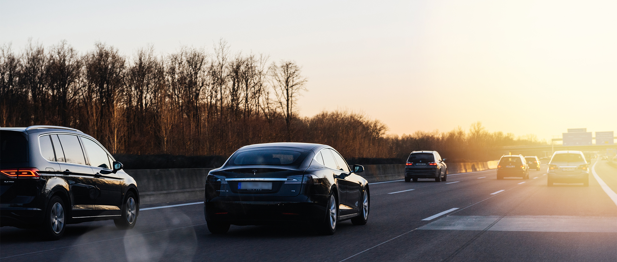Autos fahren auf einer Autobahn im Sonnenuntergang.