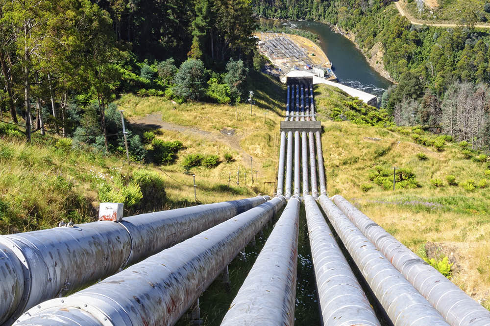 Rohre eines Pumpspeicherkraftwerks führen einen Berg hinab. 