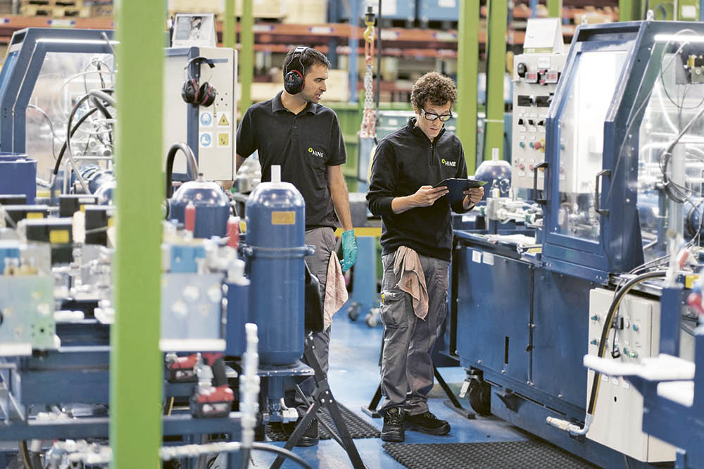 Zwei Personen stehen in einer Fabrik.