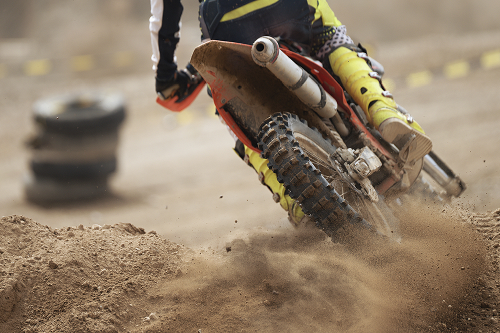 Ein Motorcross-Motorrad fährt über Sand. 