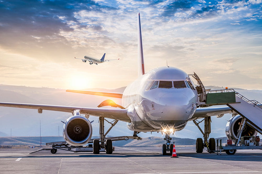 Vorderansicht eines Verkehrsflugzeugs, das bei Sonnenaufgang auf einer Flughafenrollbahn geparkt ist