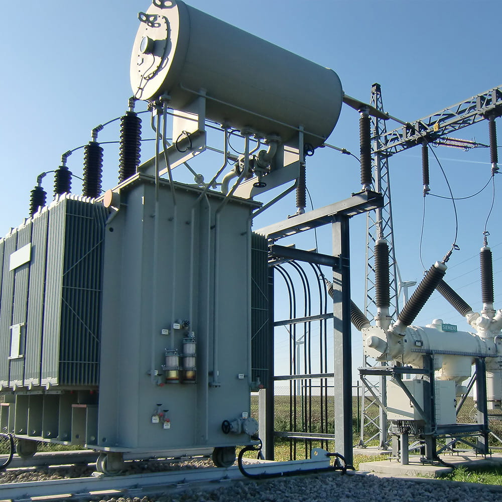 Power-Station zur Energieübertragung und Verteilung auf Wiese unter blauem Himmel