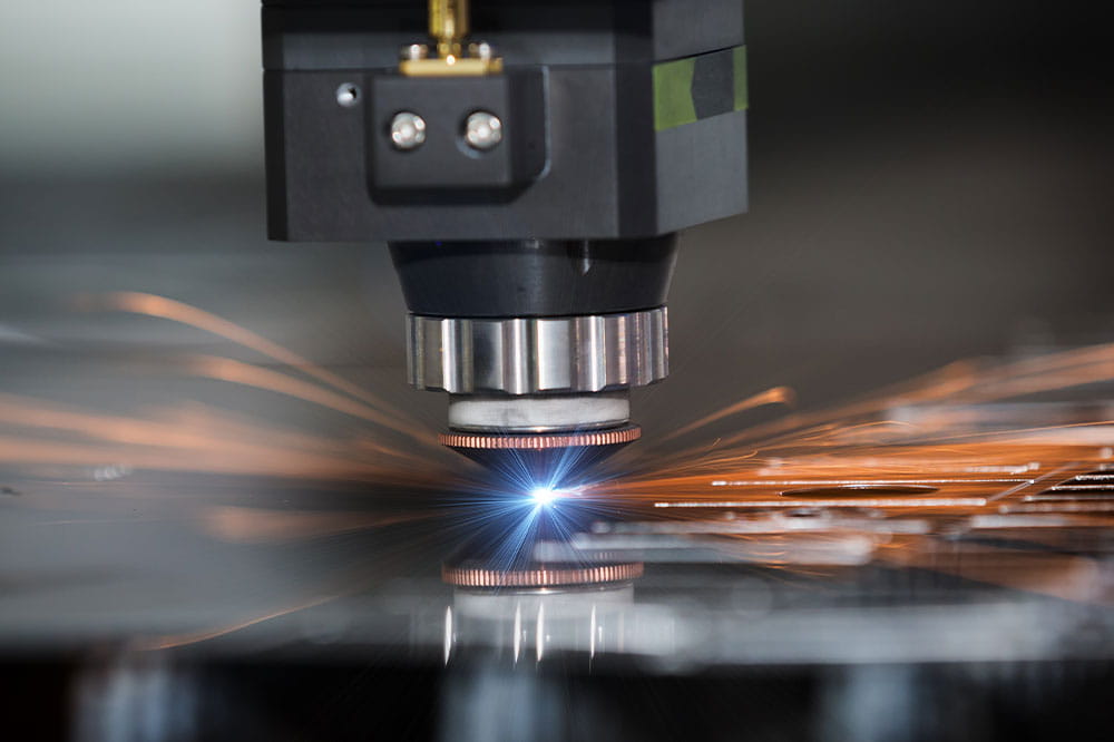 Präzise CNC-Lasermaschine schneidet Blech während Funken sprühen