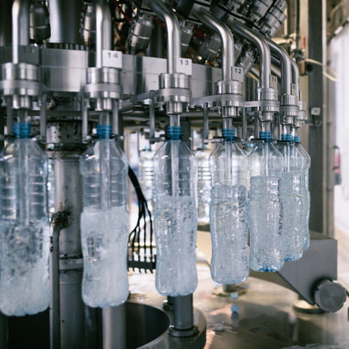 Automatisierte Anlage zur Abfüllung von Mineralwasser in blaue Kunststoffflaschen in einer Fabrik