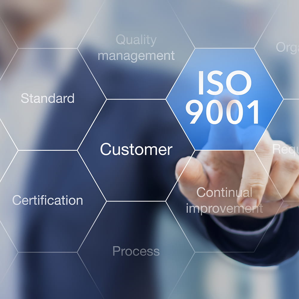 Mann im Anzug zeigt auf Wabe mit ISO 9001